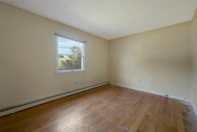 unfurnished room featuring a baseboard radiator and light hardwood / wood-style flooring