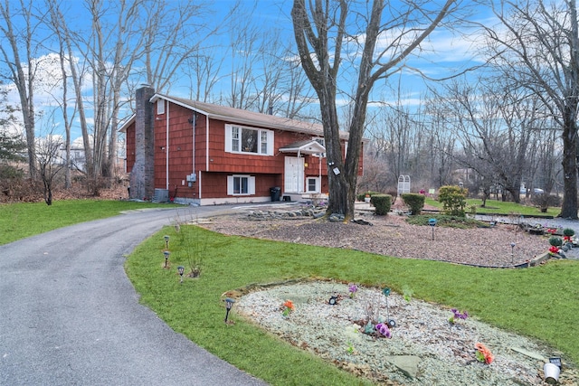 split foyer home with a front yard and cooling unit