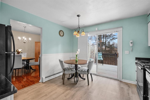 dining area with light wood-type flooring, baseboard heating, and a notable chandelier