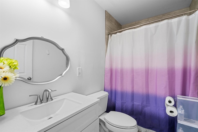 bathroom with toilet, vanity, and curtained shower