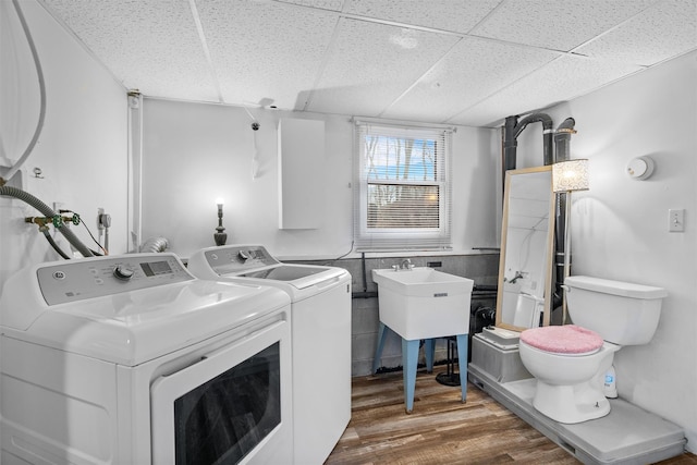 laundry area with dark hardwood / wood-style floors and washing machine and clothes dryer