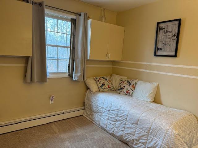 carpeted bedroom with baseboard heating