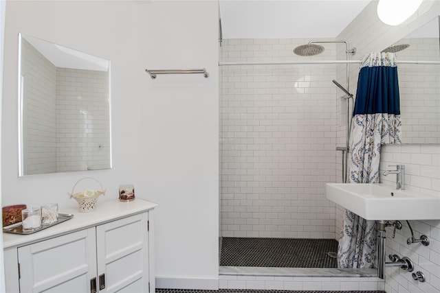 bathroom with sink and a tile shower