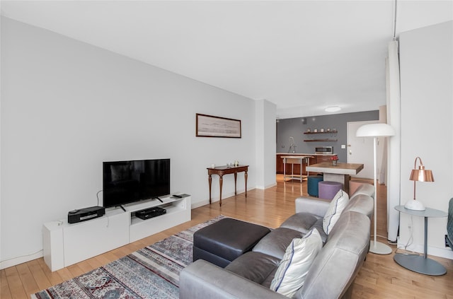 living room featuring sink and light wood-type flooring