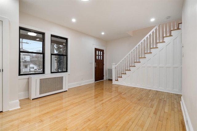 entryway featuring plenty of natural light, radiator heating unit, and light hardwood / wood-style flooring