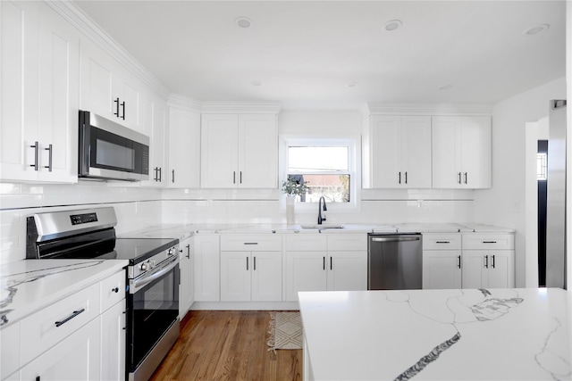 kitchen featuring light stone countertops, white cabinets, and appliances with stainless steel finishes