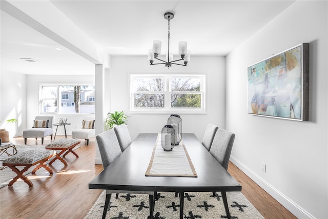 dining area with an inviting chandelier and wood-type flooring