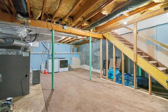 basement with washing machine and clothes dryer, carpet flooring, and heating unit