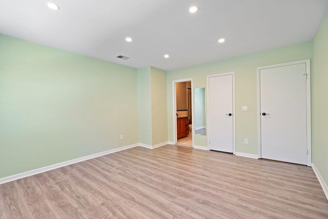 unfurnished bedroom featuring connected bathroom and light hardwood / wood-style floors