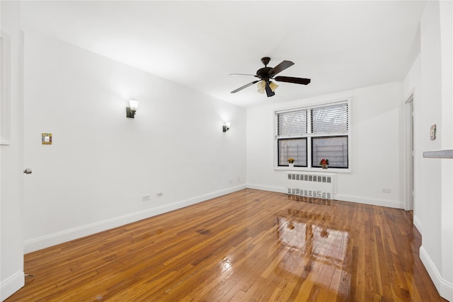 unfurnished room with ceiling fan, wood-type flooring, and radiator