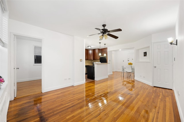 unfurnished living room with hardwood / wood-style flooring and ceiling fan