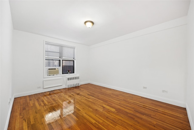 interior space with hardwood / wood-style floors, cooling unit, and radiator