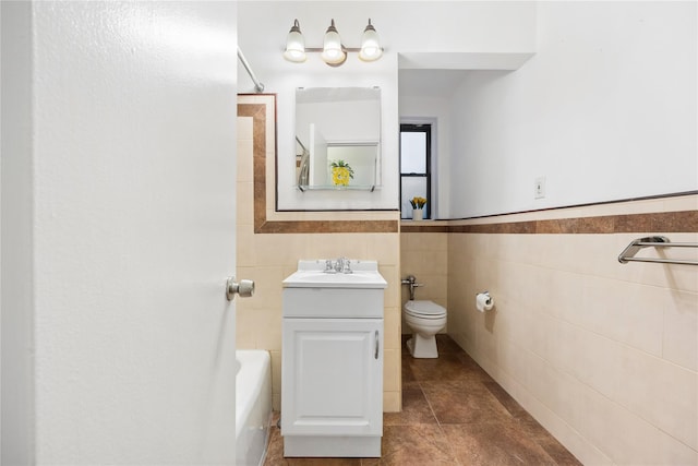 bathroom featuring toilet, tile patterned flooring, tile walls, a bath, and vanity