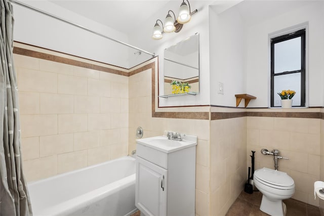 full bathroom with toilet, shower / tub combo with curtain, tile walls, tile patterned floors, and vanity