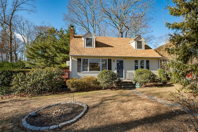 cape cod home featuring a front lawn