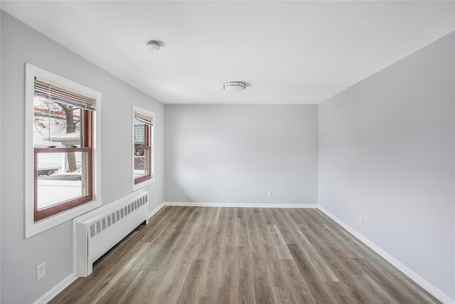 unfurnished room with radiator and light hardwood / wood-style flooring