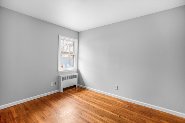 empty room with light hardwood / wood-style floors and radiator