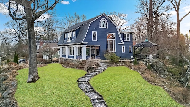 back of house featuring a gazebo, a sunroom, and a lawn