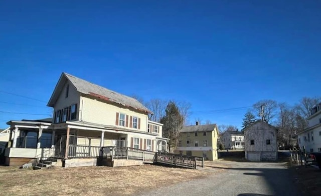 rear view of house featuring covered porch