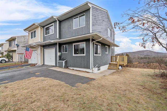 view of front facade featuring a front lawn, a mountain view, and a garage