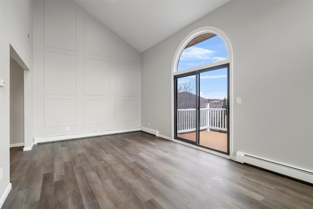 empty room with lofted ceiling, wood-type flooring, and a baseboard radiator