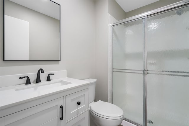 bathroom with toilet, a shower with door, and vanity