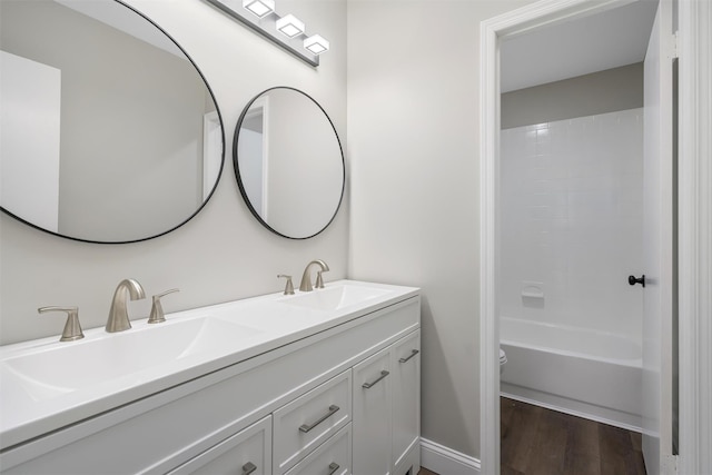 full bathroom with toilet, vanity, washtub / shower combination, and hardwood / wood-style floors