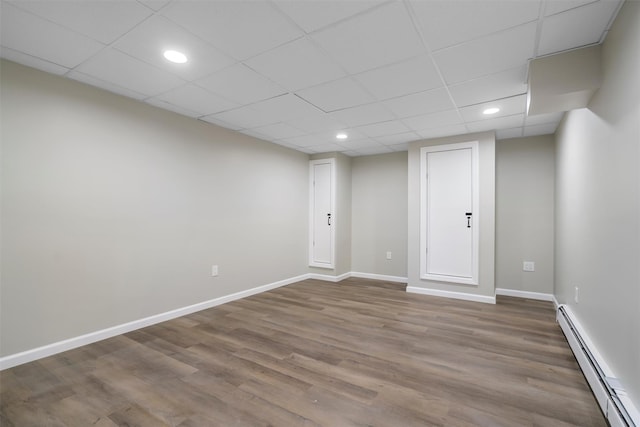 basement featuring baseboard heating and hardwood / wood-style floors