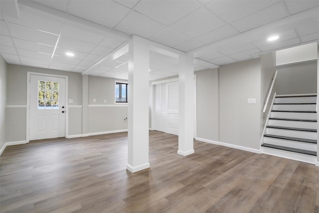 basement featuring a drop ceiling and hardwood / wood-style floors