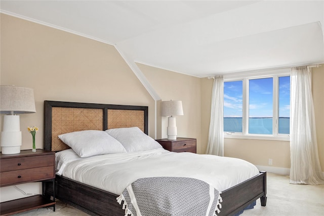 bedroom featuring a water view, light carpet, and lofted ceiling