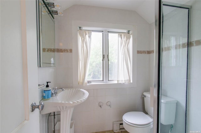 bathroom with a baseboard heating unit, tile walls, toilet, and vaulted ceiling