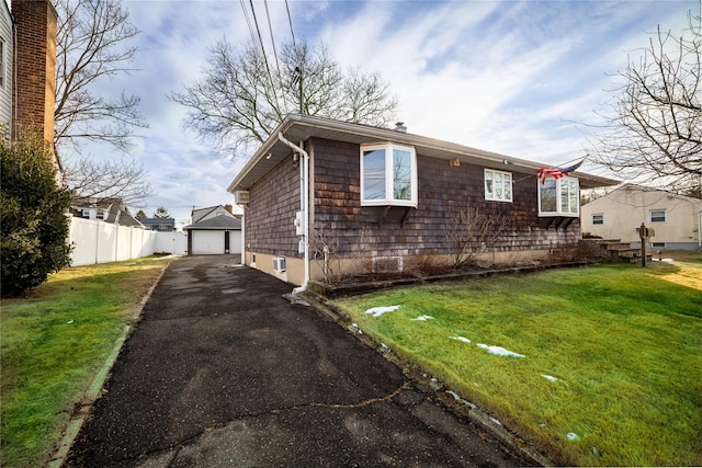 view of side of home with a garage, an outdoor structure, and a lawn