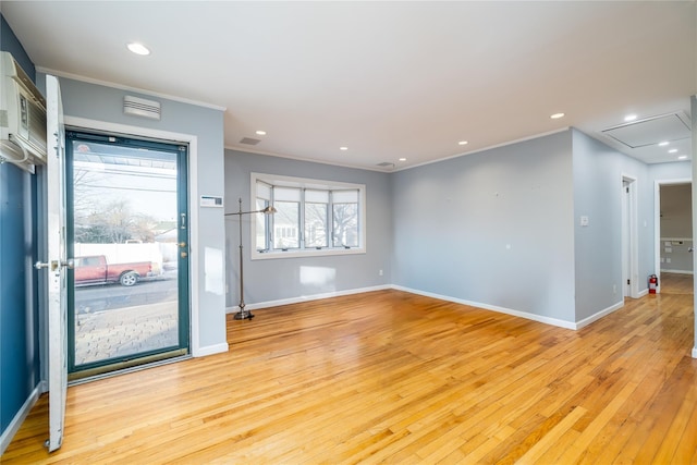 spare room featuring crown molding and light wood-type flooring