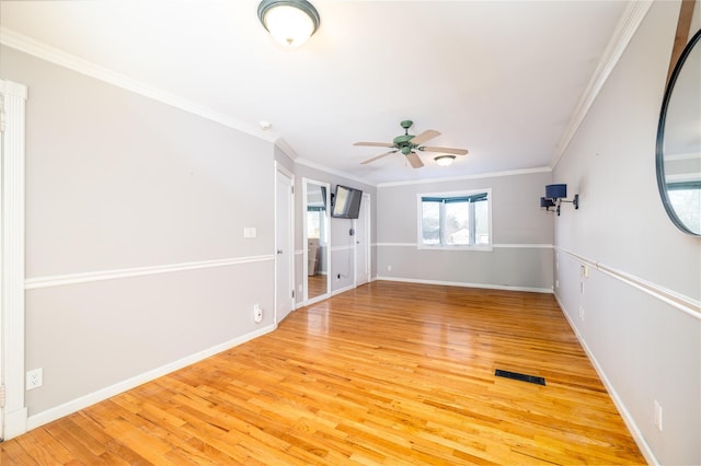 unfurnished room featuring hardwood / wood-style flooring, ceiling fan, and crown molding