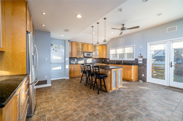 kitchen featuring pendant lighting, a breakfast bar area, backsplash, a center island, and stainless steel appliances