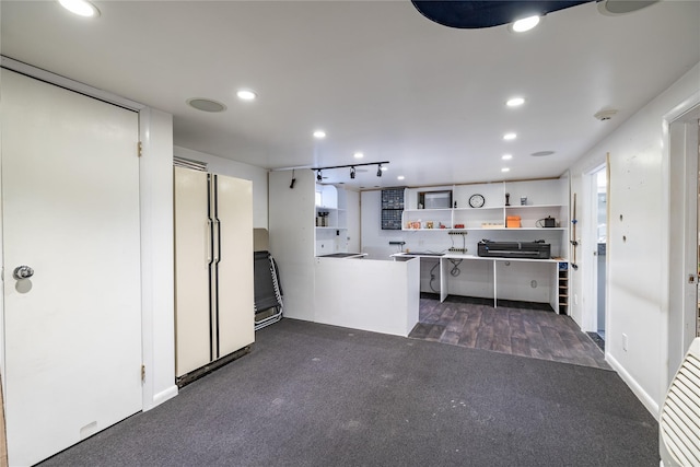 kitchen featuring kitchen peninsula, dark carpet, and white fridge