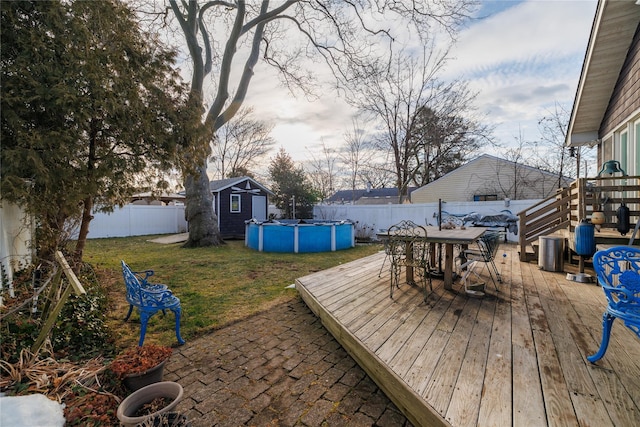 view of yard with a pool side deck and a storage shed