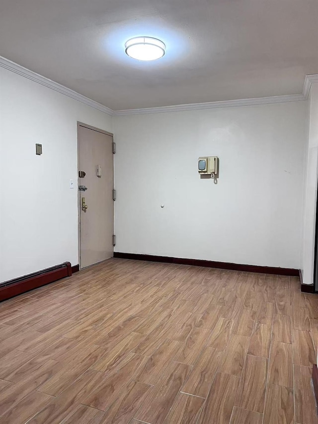 unfurnished room featuring ornamental molding and light wood-type flooring