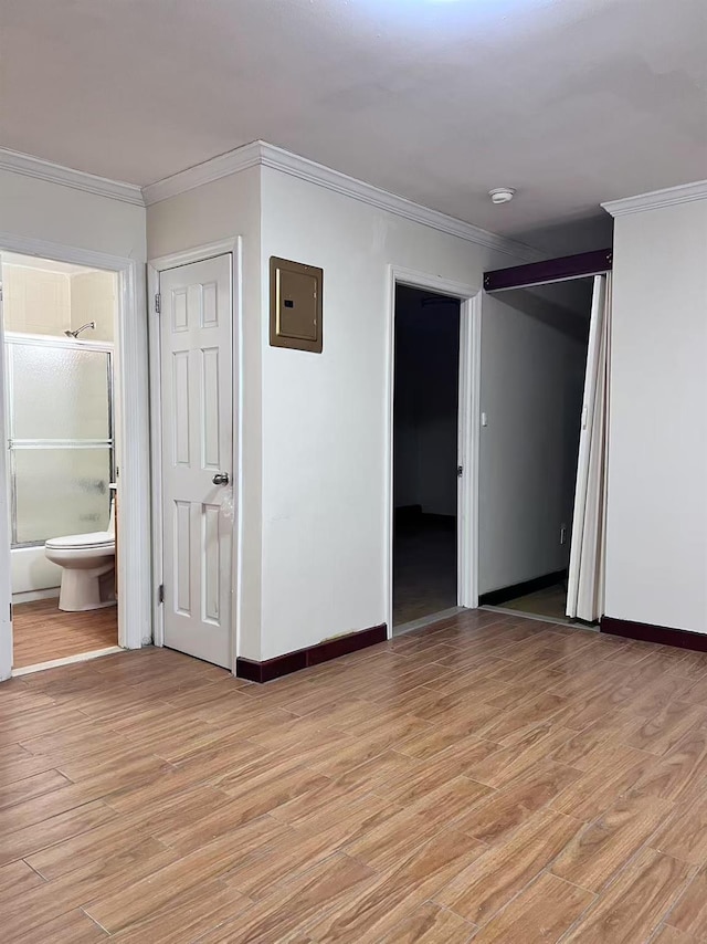 unfurnished room featuring electric panel, light hardwood / wood-style flooring, and crown molding