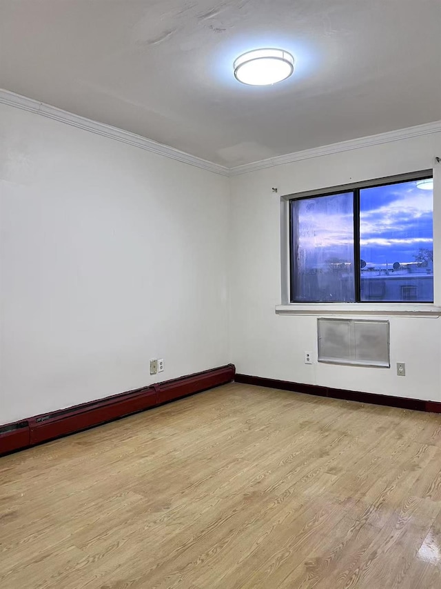 unfurnished room with a baseboard radiator, light hardwood / wood-style floors, and crown molding