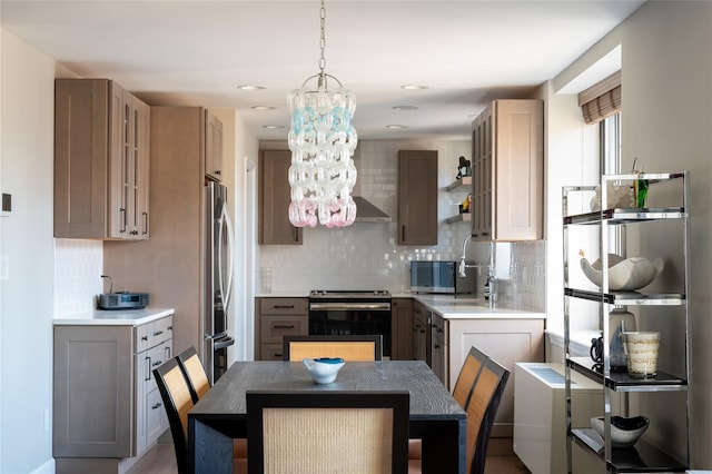 kitchen featuring a notable chandelier, stainless steel appliances, backsplash, and pendant lighting