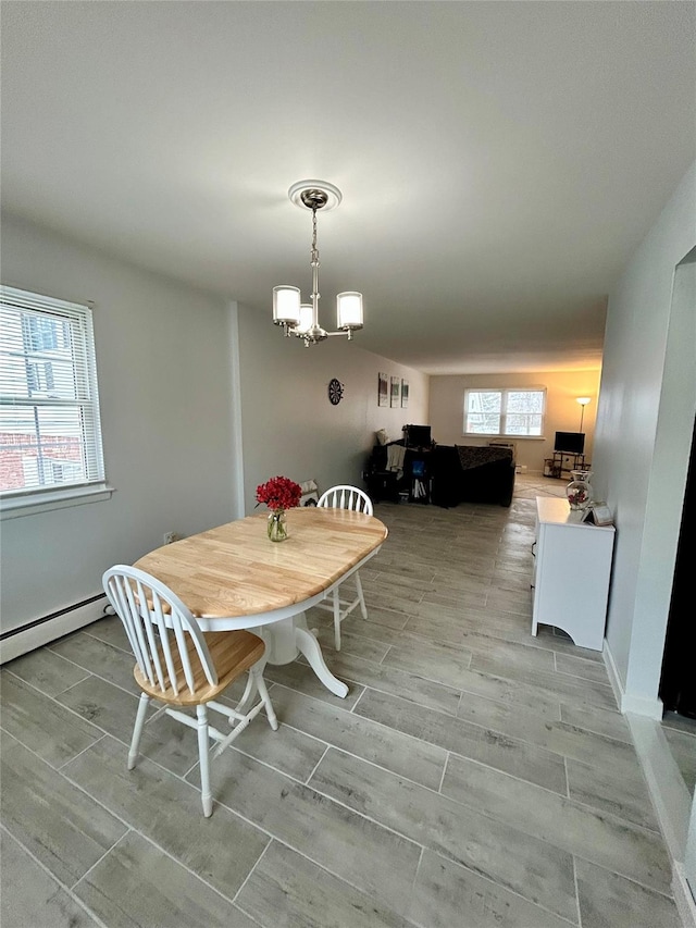 dining area with an inviting chandelier and a baseboard heating unit