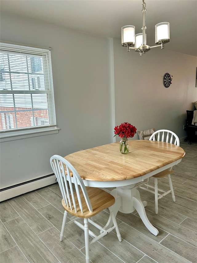 dining space with a baseboard heating unit and an inviting chandelier