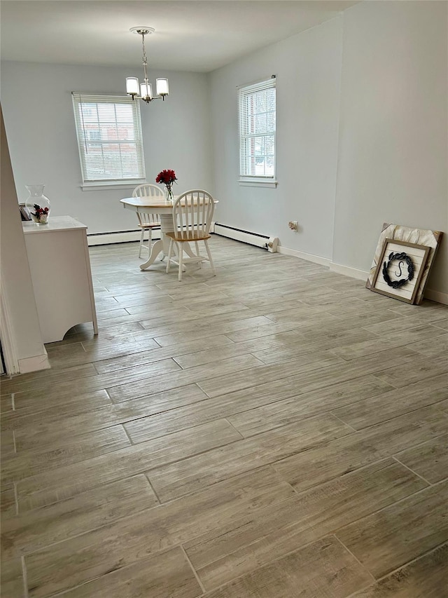 unfurnished dining area featuring a notable chandelier, a baseboard radiator, and light hardwood / wood-style floors