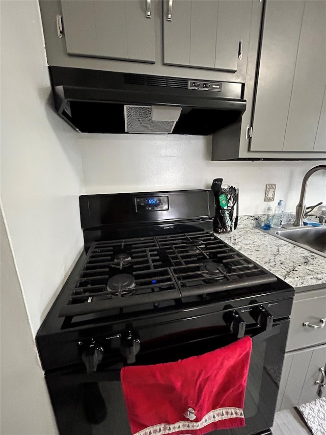 details featuring gray cabinets, sink, and black gas range oven