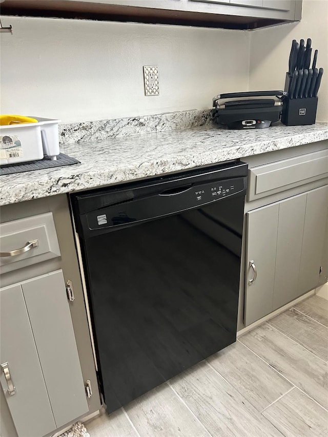 room details featuring gray cabinets, dishwasher, and light stone counters