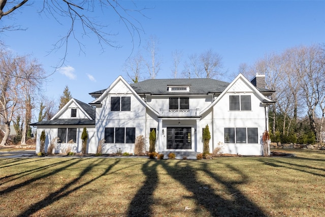 view of front of home featuring a front yard and a balcony