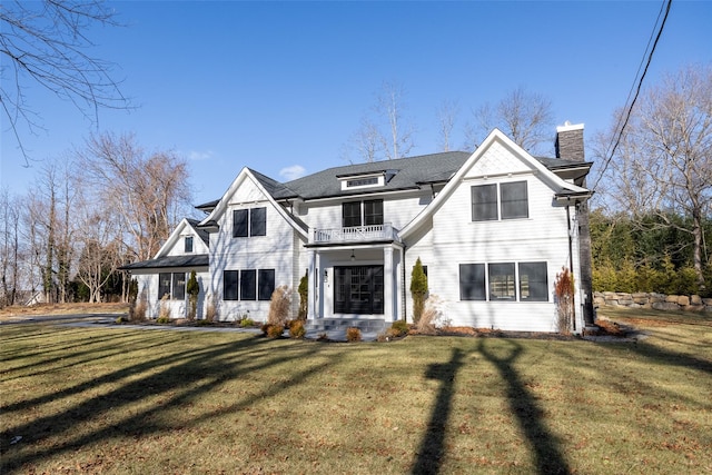 view of front of property featuring a balcony and a front yard