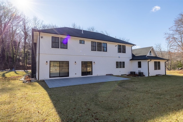 rear view of house with central AC, a patio area, and a yard