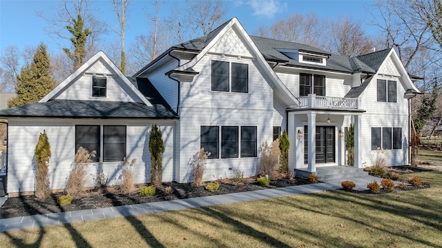 view of front of home featuring a balcony and a front lawn